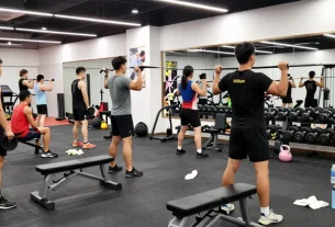 Anabolikashop - Bodybuilder trainiert intensiv im modernen Fitnessstudio mit Gewichten und Fitnessgeräten.